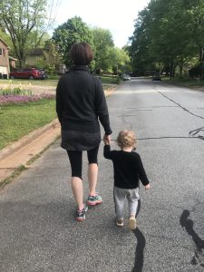 Jacqueline McCracken and her son walk down a street. We see them from behind.