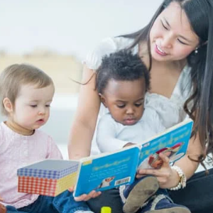 Adult reads to two young children/toddlers